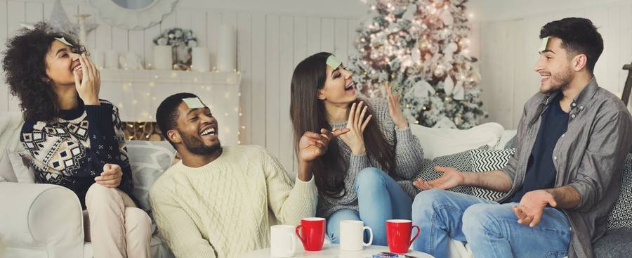 Amis riant autour d'un jeu de Noël
